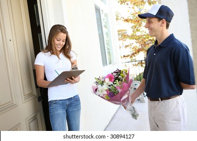 A  Delivery Man Giving Flowers To Pretty Woman At Home