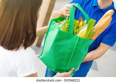 Delivery Man Giving Grocery Bag To A Woman - Food Shopping Service Concept