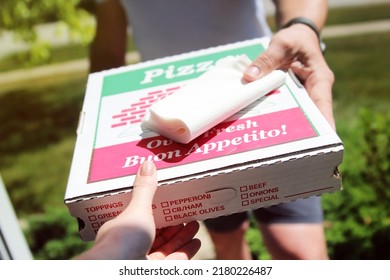 Delivery man is  giving pizza to customer on the doorstep. - Shutterstock ID 2180226487