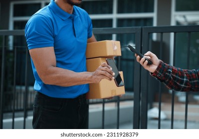 Delivery man handing parcel box to customer, percel box being paid with contactless nfc payment with phone. - Powered by Shutterstock