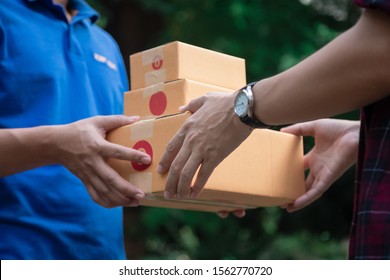 Delivery man holding boxes person who sent the letter to the package box to the recipient to arrive at home
