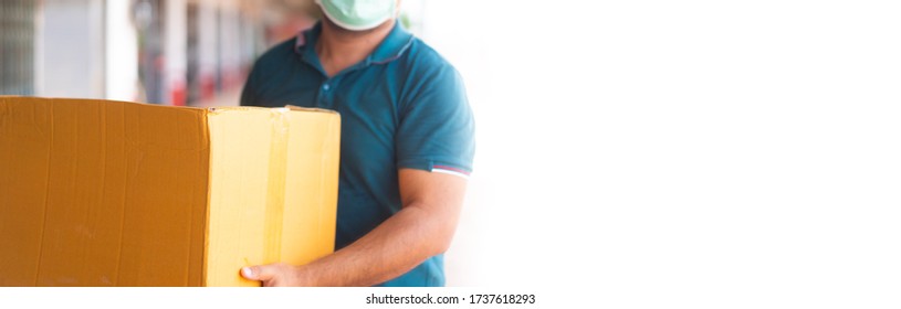 Delivery Man Holding Cardboard Box Wearing Medical Face Mask.Logistic Delivery Transport.Online Shopping And Express Delivery.Donate Food Box, Delivery Business, Lock Down,People, Covid-19 Coronavirus