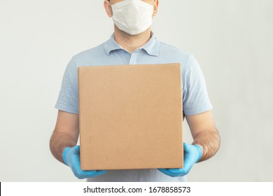 Delivery Man Holding Cardboard Boxes In Medical Rubber Gloves And Mask. Copy Space. Fast And Free Delivery Transport . Online Shopping And Express Delivery . Quarantine 