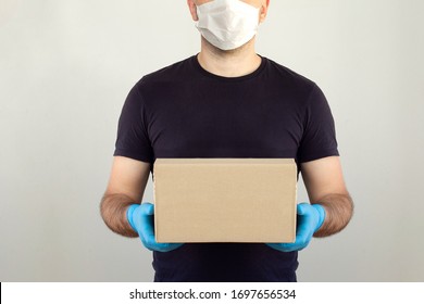 Delivery man holding cardboard boxes in medical rubber gloves and mask. copy space. Fast and free Delivery transport . Online shopping and Express delivery . Quarantine. Mockup  - Shutterstock ID 1697656534