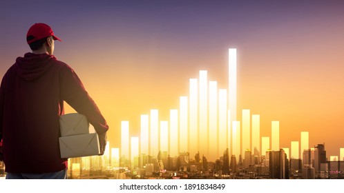 Delivery man holding cardboard boxes on bar graph and city background. Online Shopping and Express delivery Concept. - Powered by Shutterstock