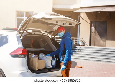 Delivery Man Holding Paper Bag With Food Near The Car, Food Delivery Man In Protective Mask