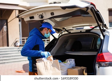 Delivery Man Holding Paper Bag With Food Near The Car, Food Delivery Man In Protective Mask