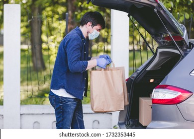 Delivery Man Holding Paper Bag With Food Near The Car, Food Delivery Man With Protective Mask And Gloves