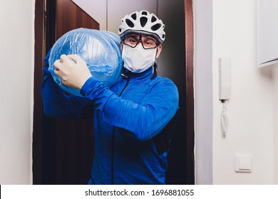 Delivery man holding water delivery in medical rubber gloves and mask. copy space. Fast and free Delivery transport . Online shopping and Express delivery . Quarantine.