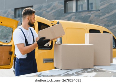 Delivery man loading cardboard boxes into a yellow van, preparing for shipment and distribution