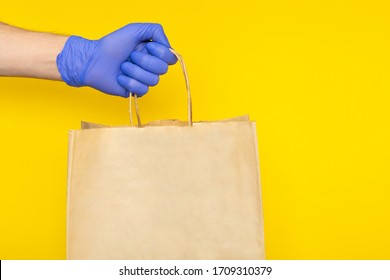 Delivery Man In Medical Gloves Holding Paper Craft Bag With Food Container, Supplies From Grocery Store Isolated. Safe Contactless Delivery Service, Takeout In Quarantine Coronavirus Pandemic. Mock Up