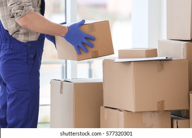 Delivery man moving boxes indoors