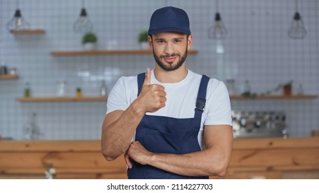 Delivery man in overalls showing like gesture at home - Shutterstock ID 2114227703