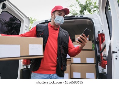 Delivery Man With Package And Smartphone Or Digital Scanner While Wearing Protective Face Mask At Work