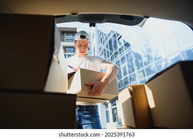 Delivery Man Picking Up Box From Car.