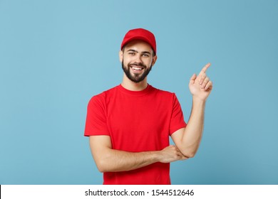 Delivery Man In Red Uniform Workwear Isolated On Blue Wall Background, Studio Portrait. Professional Male Employee In Cap T-shirt Print Working As Courier Dealer. Service Concept. Mock Up Copy Space