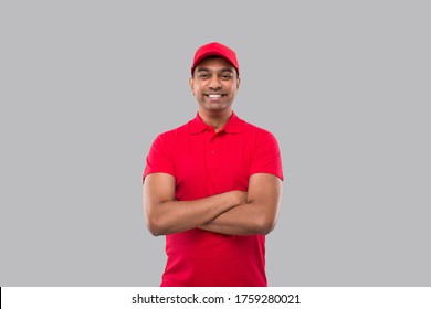 Delivery Man Standing Hands Crossed Smiling. Indian Delivery Boy in Red Uniform Isolated