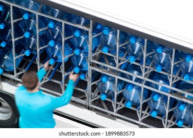 delivery  man unfocused in motion blur working distributing mineral water in plastic bottles in van car
