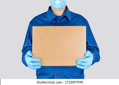 Delivery Man In Uniform With Box Isolated On Gray Background. Medical Supplies Delivery. 