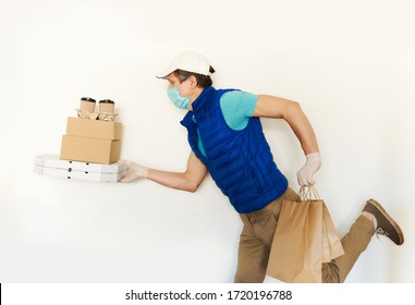 Delivery Man In Uniform Face Mask Gloves Carrying Many Cardboard Boxes, Running And Hurrying To Deliver Takeout Food. Food Delivery Service Or Shopping Order Online.