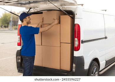 Delivery man using van full of cardboard boxes and packages, loading parcels into truck