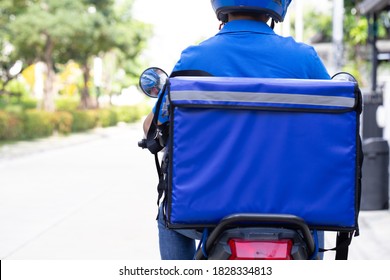 Delivery Man Wearing Blue Uniform Riding Motorcycle And Delivery Box. Motorbike Delivering Food Or Parcel Express Service