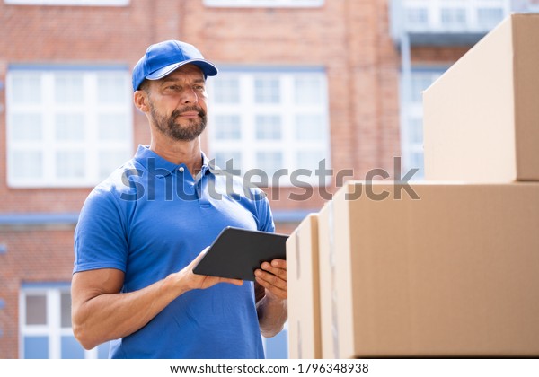 Delivery Man Worker Using Tablet For Truck\
Transport Service