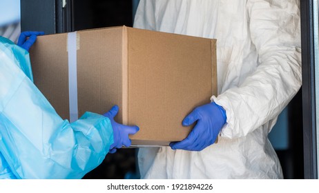 Delivery Of Medical Equipment To The Hospital. People In Protective Suits Hand Over Boxes.