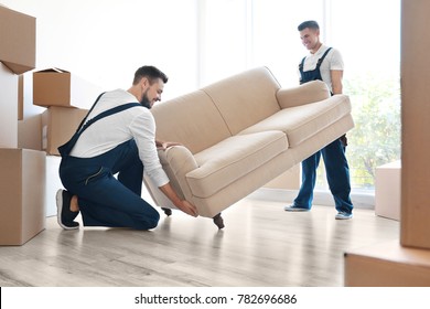 Delivery men moving sofa in room at new home - Powered by Shutterstock