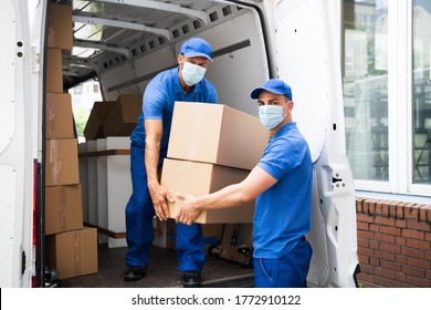 Delivery Men Unloading Cardboard Boxes From Truck With Face Mask