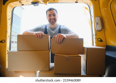 Delivery men unloading moving boxes from car.