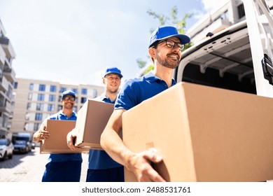 Delivery men working together to transport a cardboard box in front of a truck. Professional movers providing efficient courier services. - Powered by Shutterstock