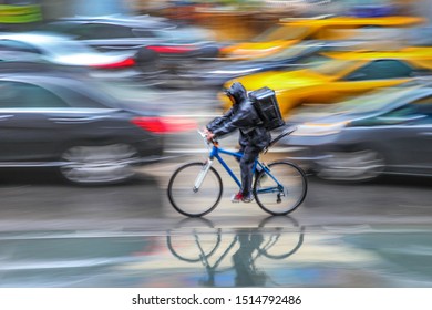 Delivery On The Bike In Traffic On The City Roadway  Motion Blur In Rainy Weather