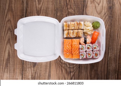 Delivery Service Japanese Food Rolls In Plastic Box On A Wooden Background