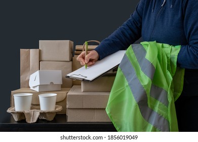 Delivery service worker stays near workplace with boxes and writes on tablet. - Shutterstock ID 1856019049