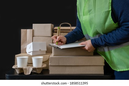 Delivery service worker stays near workplace with boxes and writes on tablet. - Shutterstock ID 1858511395