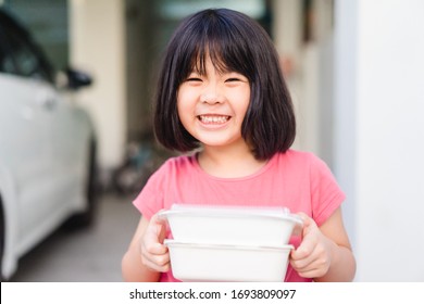 Delivery Service,Takeaway, Food Delivery And Stay At Home Safe Lives From Covid19 Coronavirus.Little Asian Girl Holding Go Box Food With Hungry.Delivering Food In City.Delivery Food Service From Home.