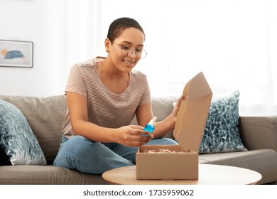 Delivery, Shipping And People Concept - Happy Young African American Woman Opening Parcel Box With Cosmetcis At Home