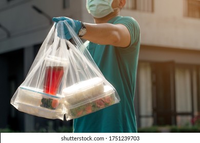 Delivery Staff Of Food Service Delivery Of Ready-to-eat Food To Customers At Home. By Wearing A Mask And Gloves To Prevent The Spread Of The Virus.