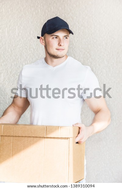 Delivery strong,\
muscular man loading cardboard boxes for moving to an apartment.\
professional worker of transportation, male loaders in overalls.\
free space for text,\
isolated