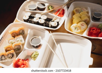 Delivery sushi rolls in plastic food container. Japanese cuisine. Set of sushi rolls in disposable containers. Food delivery service and takeout concept - Powered by Shutterstock