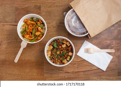 Delivery takeaway asian food. Convenient meal in paper food box on wooden table, top view - Shutterstock ID 1717170118