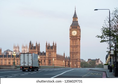 A Delivery Truck Crosses Westminster Bridge At Dawn In London. Big Ben And The Houses Of Parliament. No Traffic, No People. Early Morning.