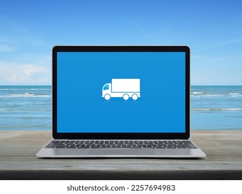 Delivery truck flat icon on modern laptop computer screen on wooden table over tropical sea and blue sky with white clouds, Business transportation online service concept - Powered by Shutterstock