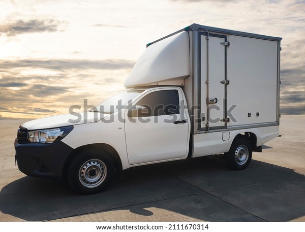 Delivery Truck Parking at\
Sunset Sky. Vans Cargo Shipping Service. Freight Truck Transport\
Logistics.