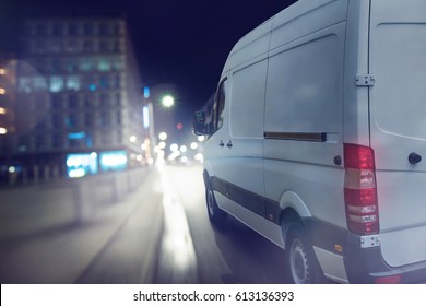Delivery van drives at night in a city