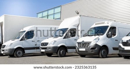 delivery white vans in service van fleet of cargo trucks courier and cars in front of the entrance of a warehouse distribution logistic society