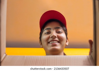 Delivery Woman Holding Cardboard Box And Looking Inside