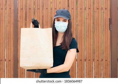 Delivery Woman Wearing Face Mask Holding Package Bag. Fast Food Worker Holding Takeaway Food  In Paper Bag 
