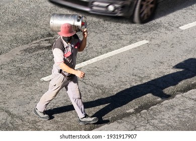 Delivery Worker With Gas Butane Bottle To Take A Customer